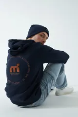 Campera de felpa color ladrillo con capucha ajustable, cierre frontal y bolsillos laterales con cierre. Tiene puños y logo bordado en la espalda.