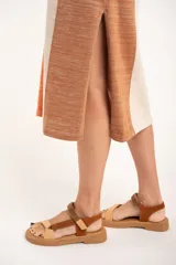 Vestido midi sin mangas, con rayas verticales en tonos naranja, beige y marrón. Confeccionado en tejido de punto suave al tacto.
