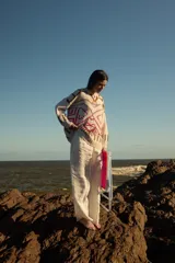 Sweater de punto color crudo con diseño geométrico en tonos marrón, rosa y lila. De corte holgado, manga larga y cuello redondo.