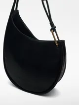 Cartera hobo de cuero sintético negro con textura granulada. Tiene un compartimento principal con cierre magnético, bolsillo interior con cremallera y asa tubular con pieza metálica dorada.