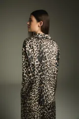 Pijama de dos piezas con estampado animal print de leopardo, compuesto por una camisa de manga larga con cuello clásico y un pantalón largo con cintura elástica.