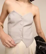 Blusa sin breteles de poliéster y viscosa, con corte recto y abotonado delantero.