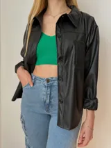 Sobrecamisa oversize de ecocuero color negro, con bolsillo delantero y puños ajustables.