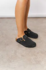 Zuecos de cuero color beige, con diseño clásico y hebilla regulable. Cuentan con plantilla anatómica y suela de corcho.