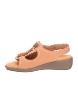 Sandalias bajas color tostado, con diseño calado en el empeine, ajuste con velcro y suela de goma.