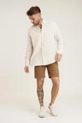 Bermuda color beige de lino, corte recto y largo a la rodilla.