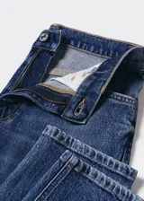 Jeans mom fit de tiro alto, color azul denim, con cinco bolsillos, cierre de cremallera y botón.