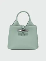 Bolso Longchamp modelo Le Roseau XS, color beige, con doble asa corta y correa larga extraíble.