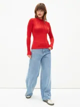 Polera roja de manga larga con textura acanalada y cuello alto.