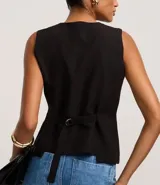 Chaleco negro de sastre, corte slim, sin mangas, con escote en V profundo y cierre frontal de cuatro botones. Presenta un bolsillo o falso bolsillo a la altura del pecho y está forrado.