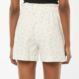 Short de tiro alto color blanco con estampado de limones amarillos, cintura elastizada con cordón ajustable y bolsillos laterales.