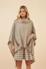 Poncho de lana color marrón con cuello alto, mangas 3/4 y bolsillo lateral con detalle de botones de cuero.