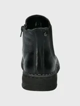 Botín Chelsea de cuero negro, estilo botineta, con elástico lateral y suela gruesa con costura visible en el borde.