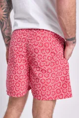 Short de baño rojo con estampado de arabescos blancos, cintura elástica y cordón ajustable.