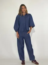Pantalón de denim azul oscuro, de corte palazzo, con tiro alto y bolsillos laterales.