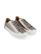 Zapatillas Hush Puppies color beige con cordones y suela blanca.