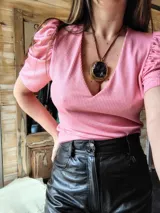 Blusa de lurex color rosado, con escote en V y mangas cortas abullonadas.