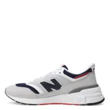 Championes New Balance modelo 997R, color gris con detalles en azul marino y rojo. Confeccionados en gamuza y malla, con logo "N" característico en los laterales.