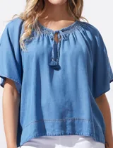 Blusa celeste de lyocell, con escote en V, punto smock y lazo de ajuste.