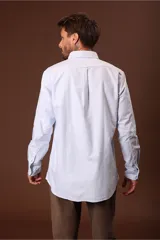 Camisa blanca de manga larga con cuello abotonado.