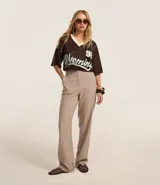 Pantalón de vestir color beige, de corte recto, confeccionado en crepé. Cuenta con cintura fija, bolsillos laterales tipo cuchillo y cierre frontal oculto.