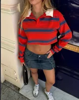 Remera corta de manga larga, con cuello polo y rayas horizontales rojas y azules.