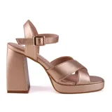 Sandalias de vestir color oro rosa, con plataforma y tacón cuadrado. Presentan tiras cruzadas en el empeine y pulsera con hebilla al tobillo.