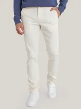 Pantalón chino color crema de corte slim fit, confeccionado en algodón pima elástico.