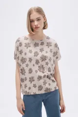 Remera blanca con estampado floral en color lila, de corte holgado y mangas cortas.