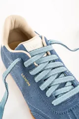 Zapatillas deportivas de gamuza color celeste con cordones celestes y suela marrón.