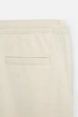 Pantalón azul marino de corte recto, con cintura elástica ajustable con cordón, bolsillos laterales y traseros.