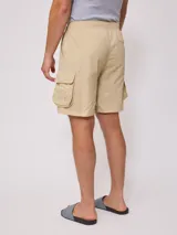 Bermuda color beige de corte recto con bolsillos cargo laterales y cintura elastizada con cordón ajustable.