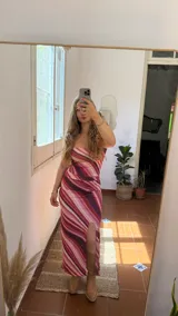 Conjunto de top strapless y falda midi con abertura lateral, confeccionado en jersey de lycra con estampado de líneas onduladas en tonos rosa, blanco y marrón. Incluye cinturón marrón con tachas plateadas.