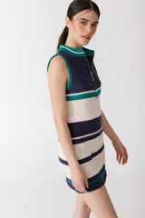 Vestido corto de punto con rayas horizontales en color rojo, marrón, beige y rosa. Tiene cuello alto con cierre de cremallera dorada y diseño sin mangas.