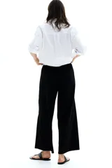Pantalón negro de punto con textura, corte holgado, tiro alto, piernas rectas, elástico revestido en la cintura y cordón para ajustar.