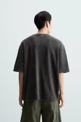 Camiseta azul marino de corte holgado, confeccionada en algodón con cuello redondo y mangas cortas. Presenta un efecto de lavado que le da una apariencia única.