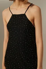 Minivestido negro con breteles finos, escote recto y apliques de strass plateados.