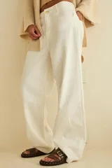 Pantalón de jean blanco de corte recto, con bolsillos delanteros y traseros, y etiqueta de marca en la cintura.
