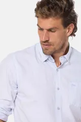 Camisa celeste a rayas verticales, de manga larga con opción de arremangar, corte slim fit y bolsillo en el pecho. Confeccionada en algodón.