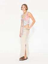 Pollera midi color beige con recortes en combinación de tejido en laterales, recortes en frente y espalda; y tajos en los laterales.