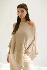 Poncho color beige de tejido de punto con cuello asimétrico.