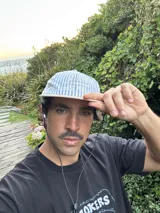 Gorro tipo gorra de visera plana, con paneles a rayas verticales azules y blancas, y visera blanca lisa. Presenta bordado en la parte frontal con el texto "LEVEIN", "MOOD THAT ONLY KNOW" y "SEE GOOD FIALN THINGS".