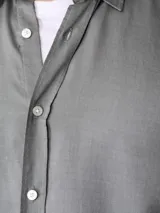 Camisa gris claro de corte slim fit, confeccionada en lyocell, con cuello clásico y cierre frontal con botones.