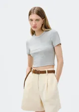 Top corto negro de manga corta, con cuello redondo y tejido acanalado.