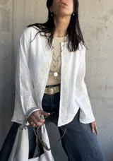 Chaqueta blanca de bambula con bordados en el cuello, mangas y frente.