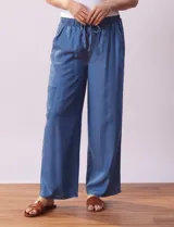 Pantalón largo de lyocell color azul, corte ancho, con pretina elastizada con lazo de ajuste, bolsillos laterales y delanteros tipo cargo.