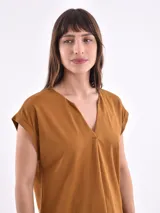 Blusa blanca de corte holgado, con cuello en V y mangas cortas.