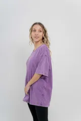 Remera oversize color lila con efecto lavado, cuello redondo y mangas cortas amplias.