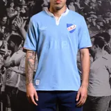 Camiseta de fútbol Umbro del Club Nacional de Football, modelo Away 3 temporada 2024. Diseño celeste con cuello polo blanco y detalles en rojo. Incluye logo de Umbro, escudo del club y sponsor Antel en el frente.