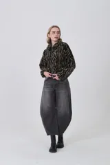 Campera corta de tejido peluche (corderito) con cierre frontal y cuello camisero. Presenta un estampado animal print de cebra o tigre en tonos marrón claro y negro.